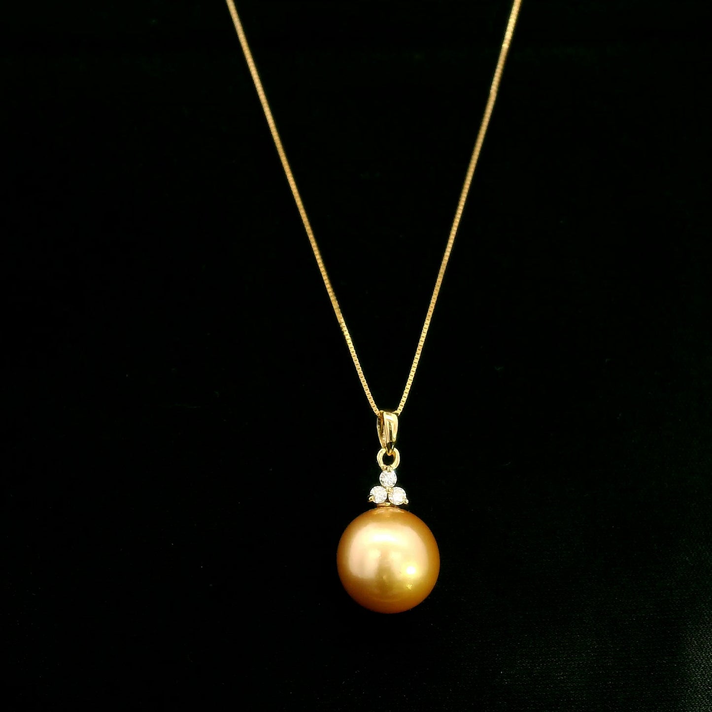 South Sea Golden Pearl and diamond pendant in 18K yellow gold featuring a 10 x 13 mm golden pearl and round diamond accents