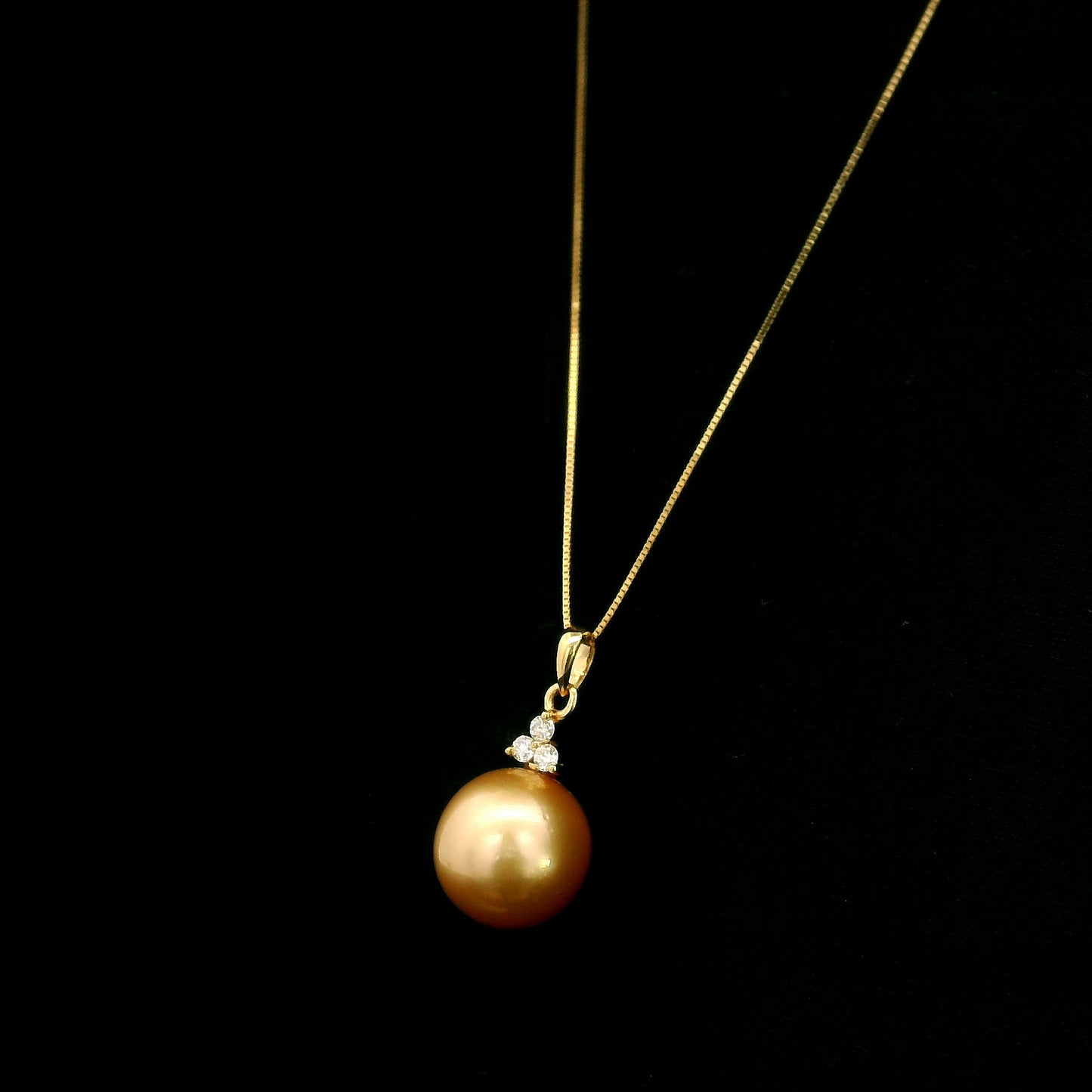 South Sea Golden Pearl and diamond pendant in 18K yellow gold featuring a 10 x 13 mm golden pearl and round diamond accents