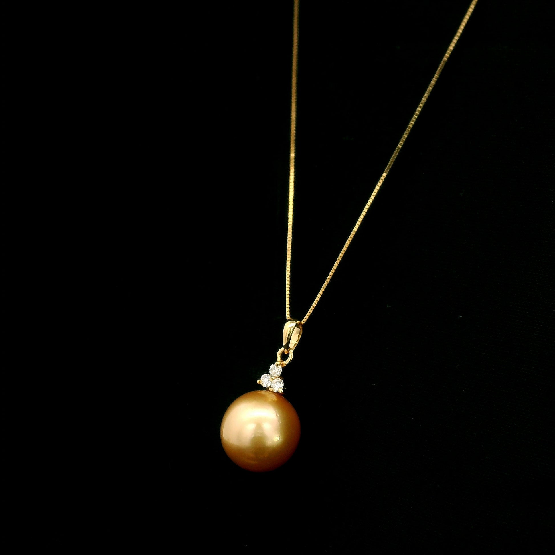 South Sea Golden Pearl and diamond pendant in 18K yellow gold featuring a 10 x 13 mm golden pearl and round diamond accents