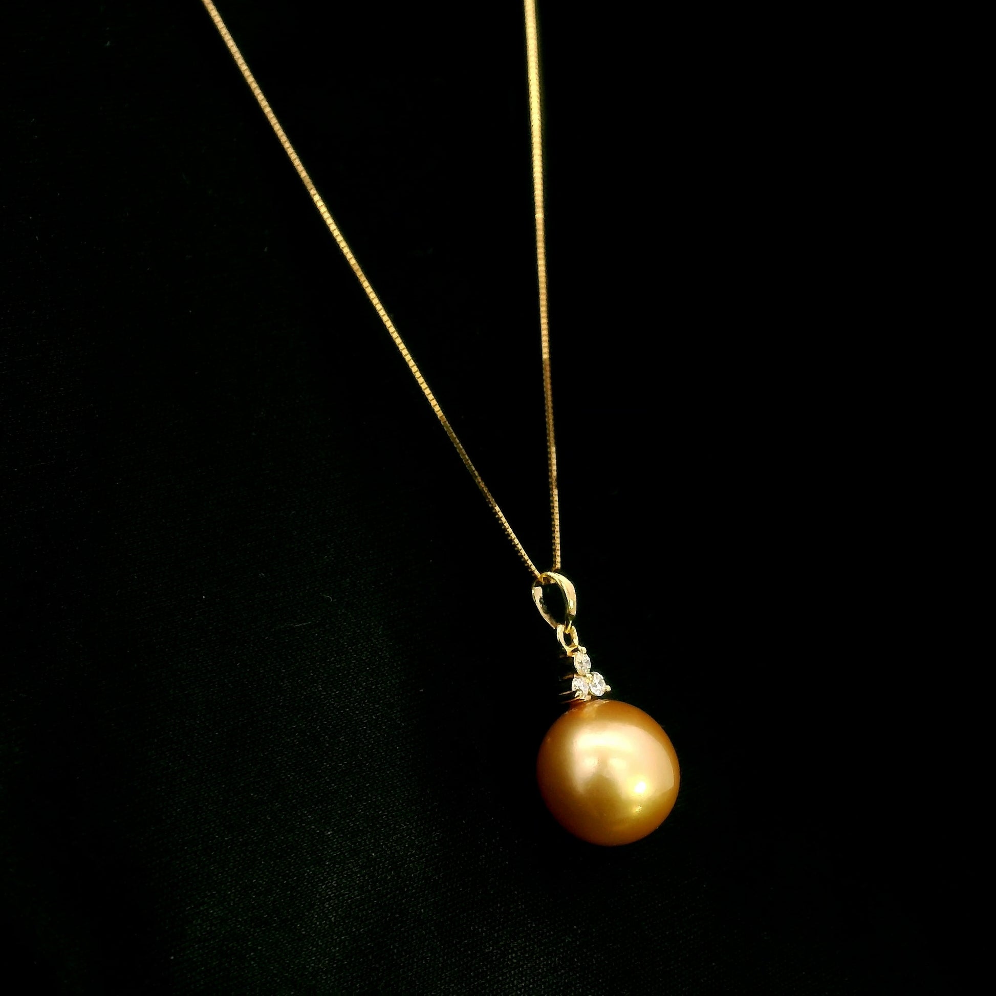 South Sea Golden Pearl and diamond pendant in 18K yellow gold featuring a 10 x 13 mm golden pearl and round diamond accents