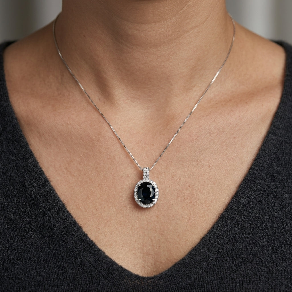 Oval sapphire and diamond halo pendant in 18K white gold with diamond-set bail
