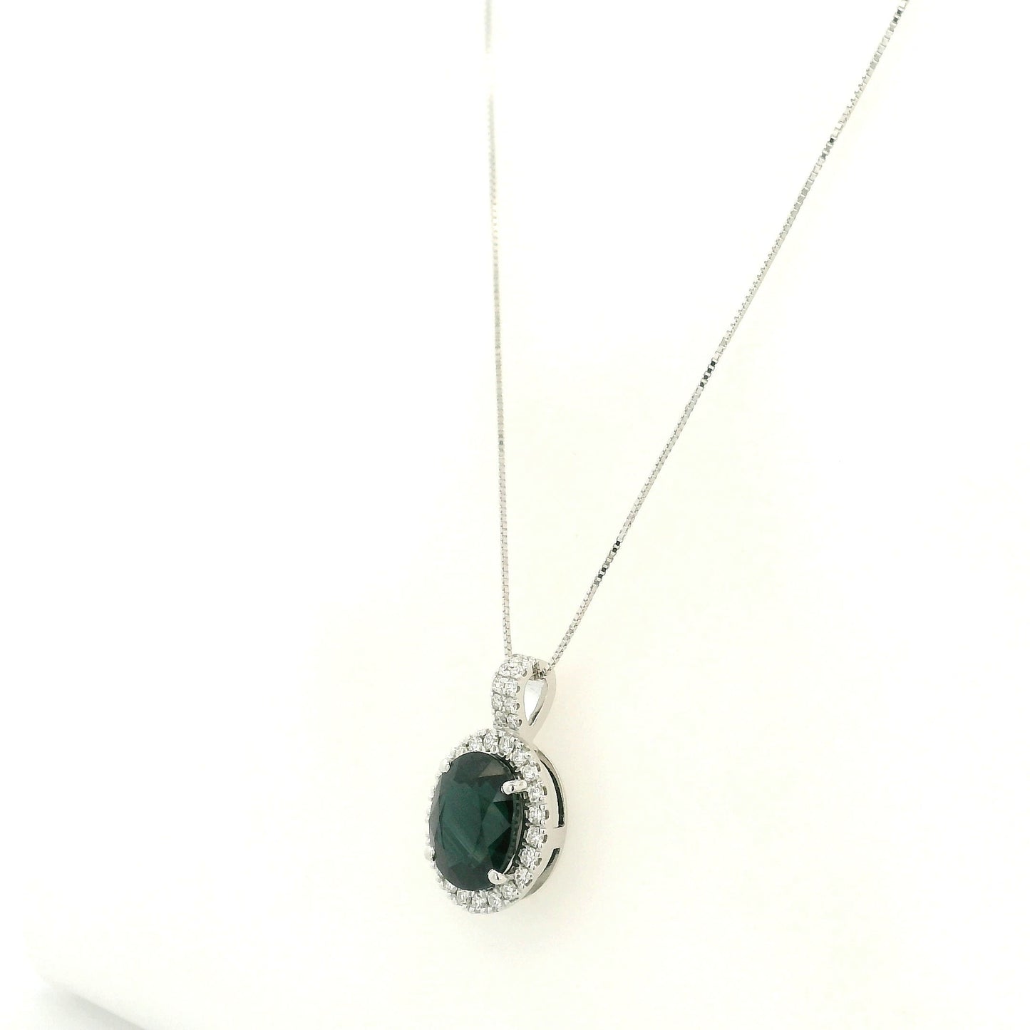 Oval sapphire and diamond halo pendant in 18K white gold with diamond-set bail