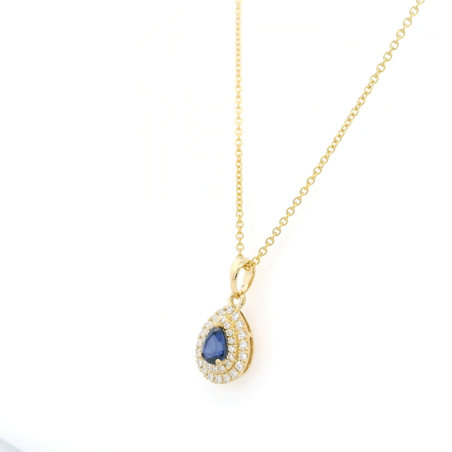 Pear shaped blue sapphire and double diamond halo pendant in 18K yellow gold
