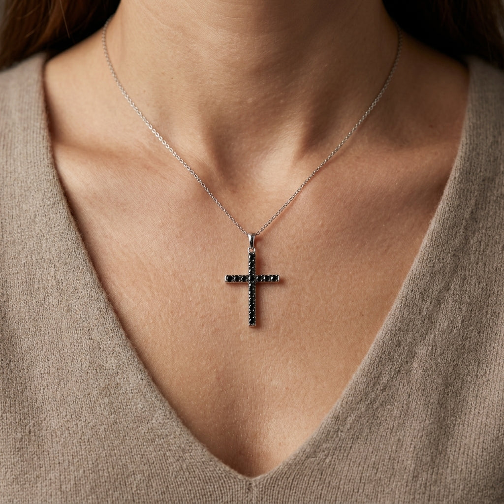 Black diamond cross pendant in 18K white gold set with round black diamonds in a slender cross design.