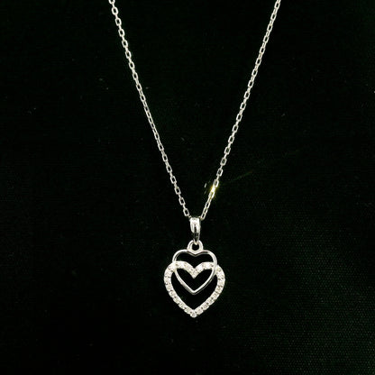 Diamond heart pendant in 18K white gold featuring overlapping open hearts with round brilliant diamond detailing.