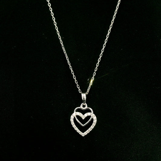 Diamond heart pendant in 18K white gold featuring overlapping open hearts with round brilliant diamond detailing.