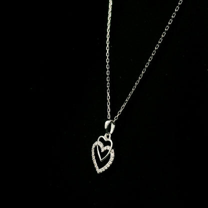 Diamond heart pendant in 18K white gold featuring overlapping open hearts with round brilliant diamond detailing.