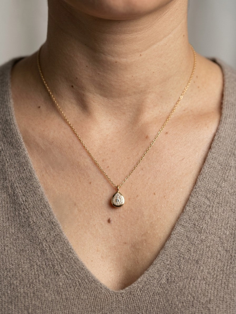Diamond teardrop pendant necklace in 18K yellow gold featuring round brilliant diamonds arranged within a pear-shaped gold frame.