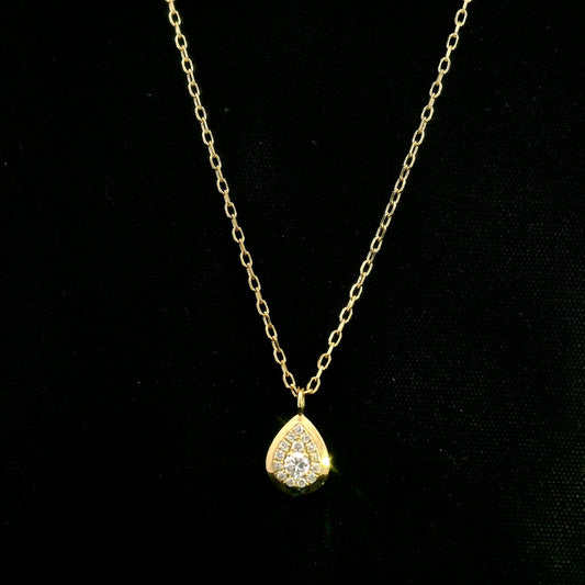 Diamond teardrop pendant necklace in 18K yellow gold featuring round brilliant diamonds arranged within a pear-shaped gold frame.