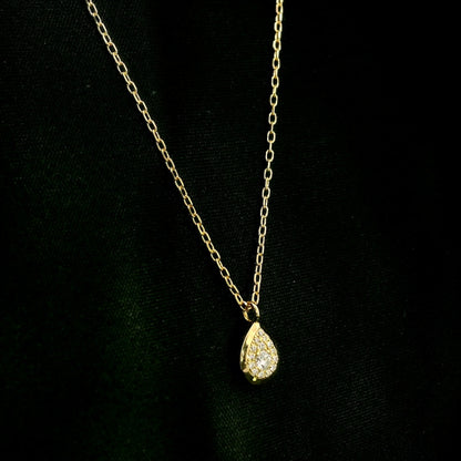 Diamond teardrop pendant necklace in 18K yellow gold featuring round brilliant diamonds arranged within a pear-shaped gold frame.