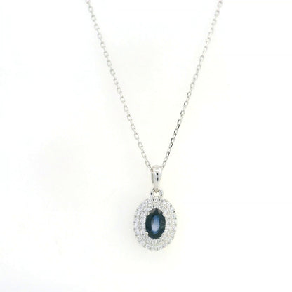 Blue sapphire and diamond halo pendant in 18K white gold with an oval sapphire surrounded by two rows of round diamonds