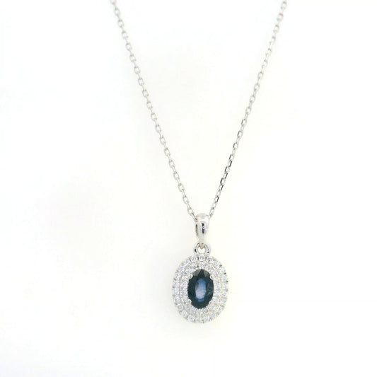 Blue sapphire and diamond halo pendant in 18K white gold with an oval sapphire surrounded by two rows of round diamonds