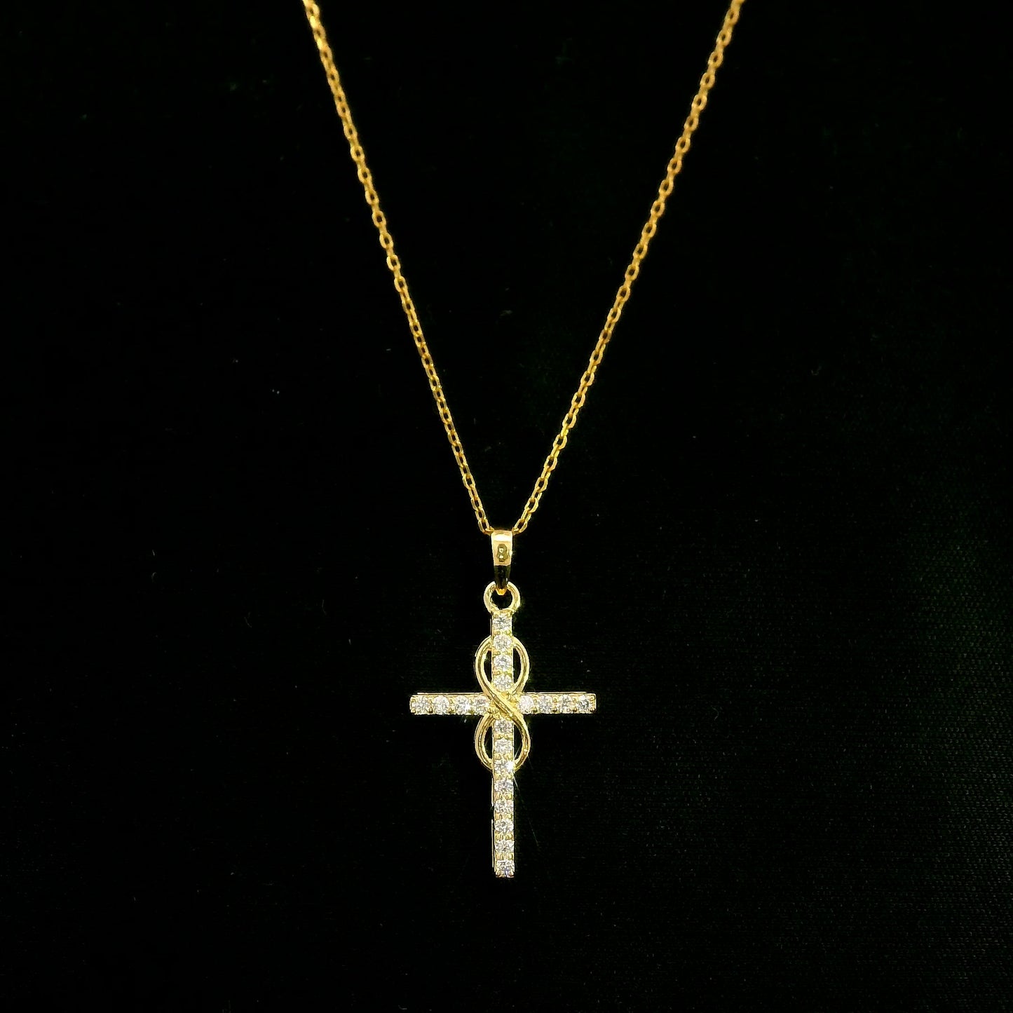 Diamond cross pendant in 18K yellow gold with round brilliant diamonds and an intertwined gold centre design