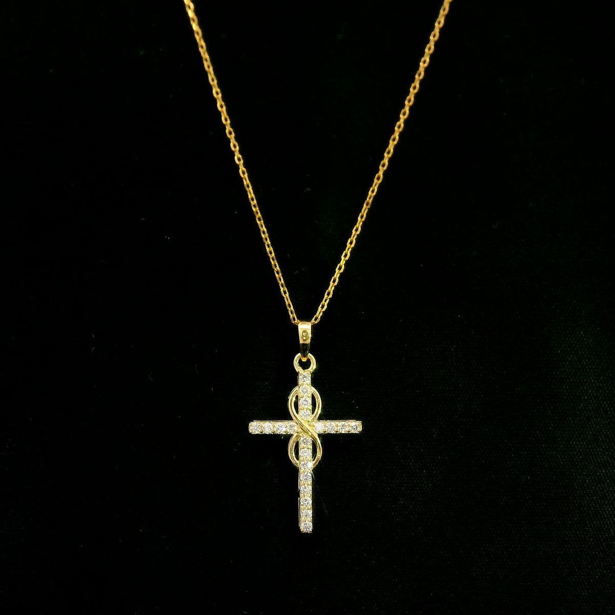 Diamond cross pendant in 18K yellow gold with round brilliant diamonds and an intertwined gold centre design