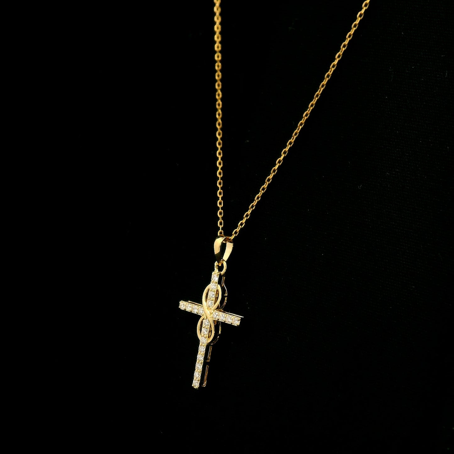 Diamond cross pendant in 18K yellow gold with round brilliant diamonds and an intertwined gold centre design