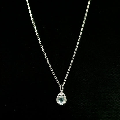 Aquamarine drop pendant necklace in 18K white gold with a round blue aquamarine and delicate diamond accent.
