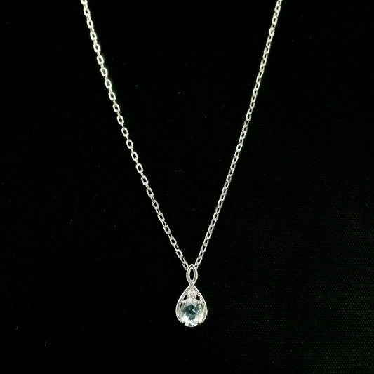 Aquamarine drop pendant necklace in 18K white gold with a round blue aquamarine and delicate diamond accent.