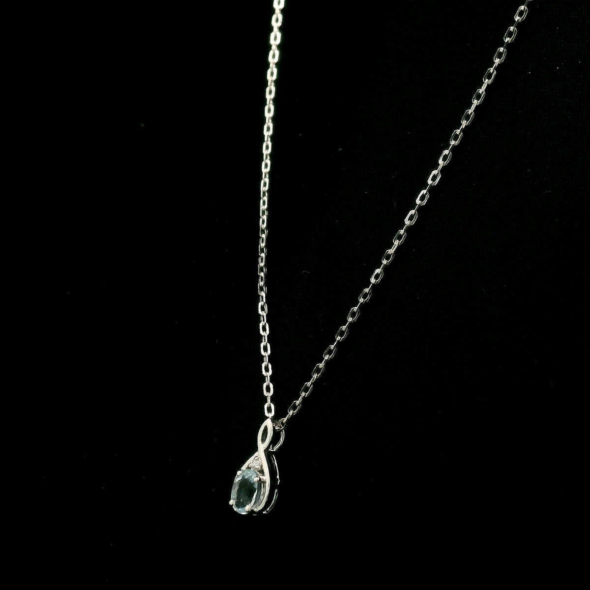 Aquamarine drop pendant necklace in 18K white gold with a round blue aquamarine and delicate diamond accent.
