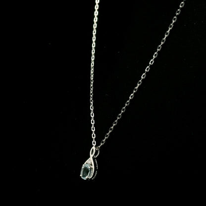 Aquamarine drop pendant necklace in 18K white gold with a round blue aquamarine and delicate diamond accent.