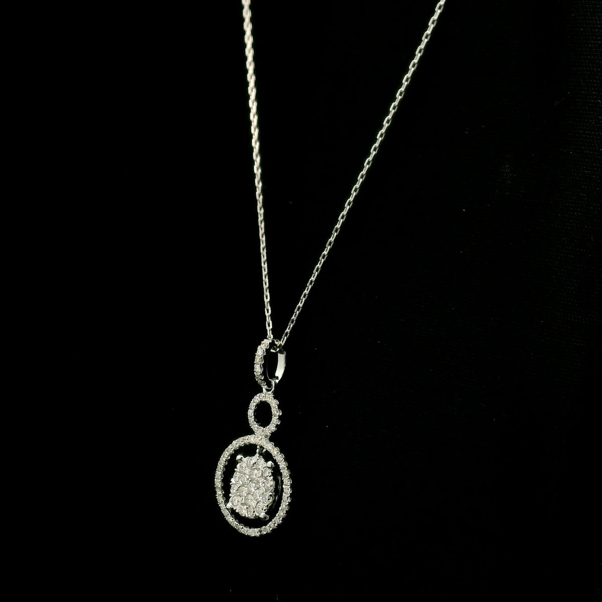 Diamond circle pendant in 18K white gold featuring a suspended diamond cluster with open circular diamond details.