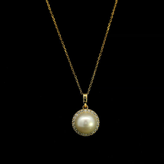 Freshwater white pearl and diamond halo pendant in 18K yellow gold with a round pearl surrounded by brilliant diamonds.