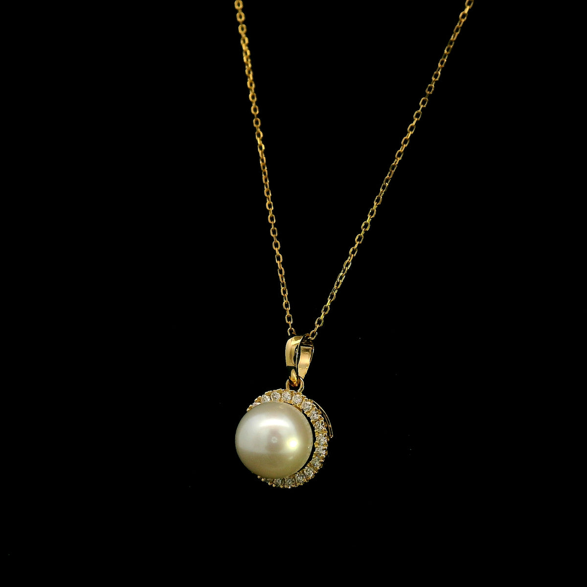 Freshwater white pearl and diamond halo pendant in 18K yellow gold with a round pearl surrounded by brilliant diamonds.