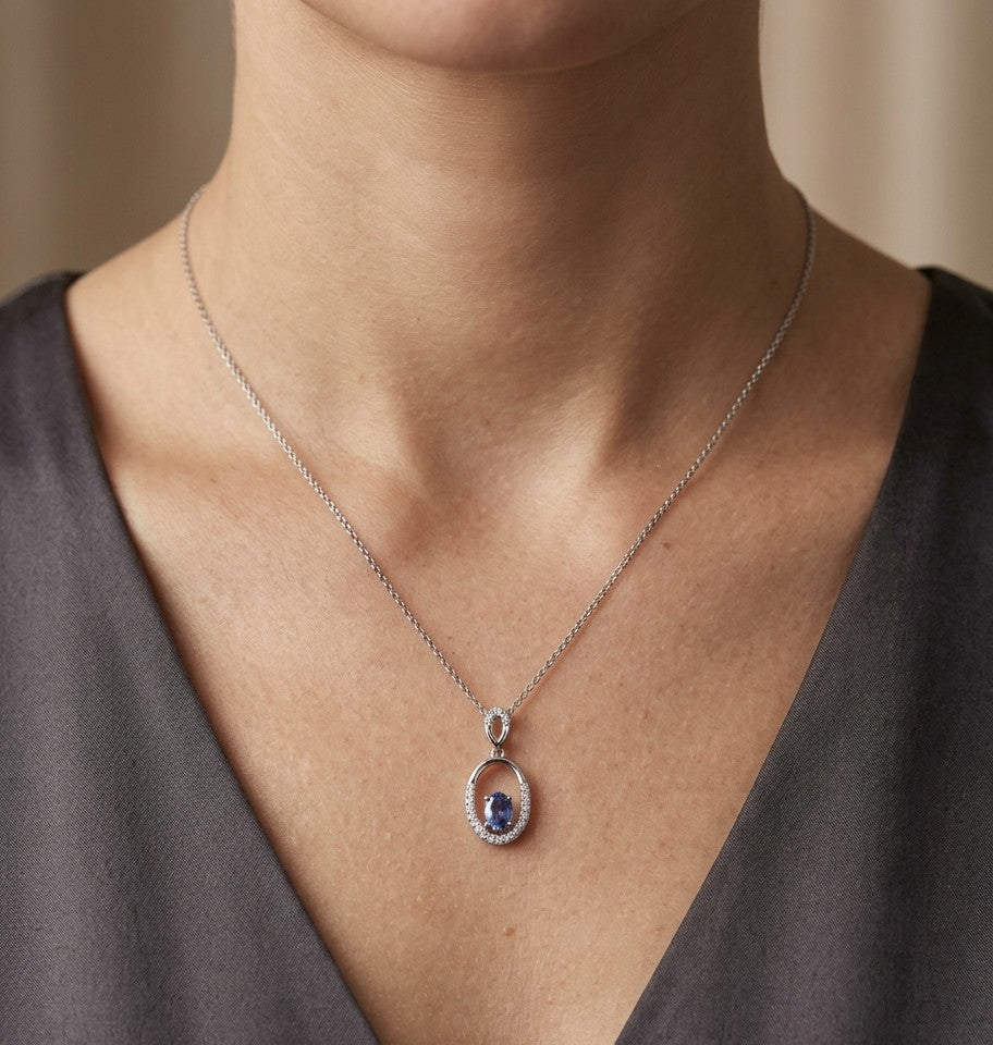 Oval blue sapphire and diamond pendant in 18K white gold with open oval design