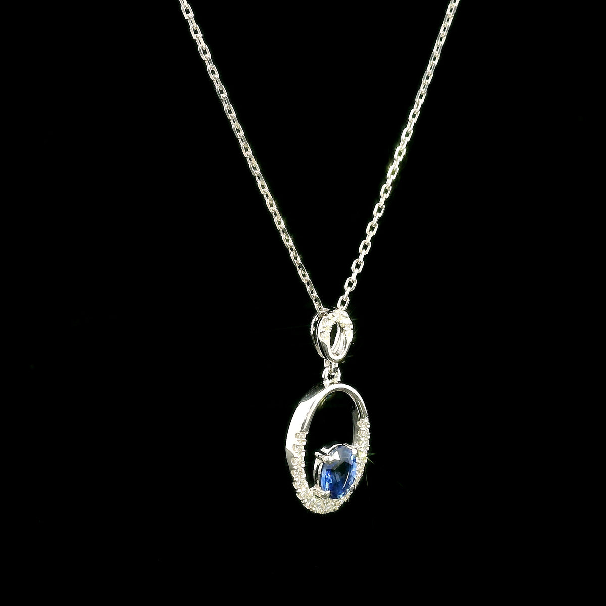 Oval blue sapphire and diamond pendant in 18K white gold with open oval design
