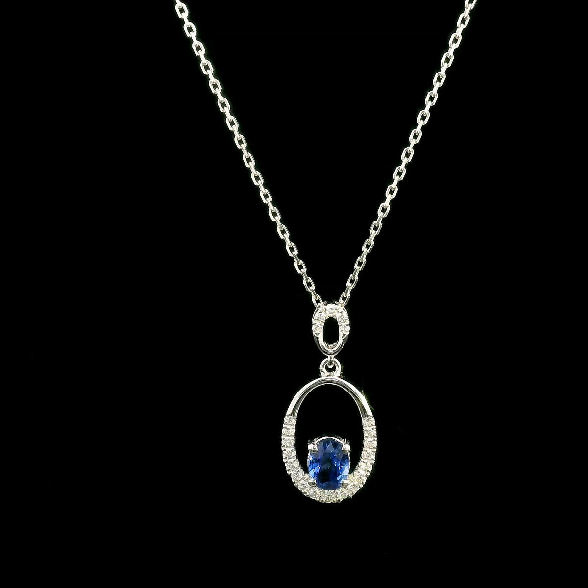 Oval blue sapphire and diamond pendant in 18K white gold with open oval design