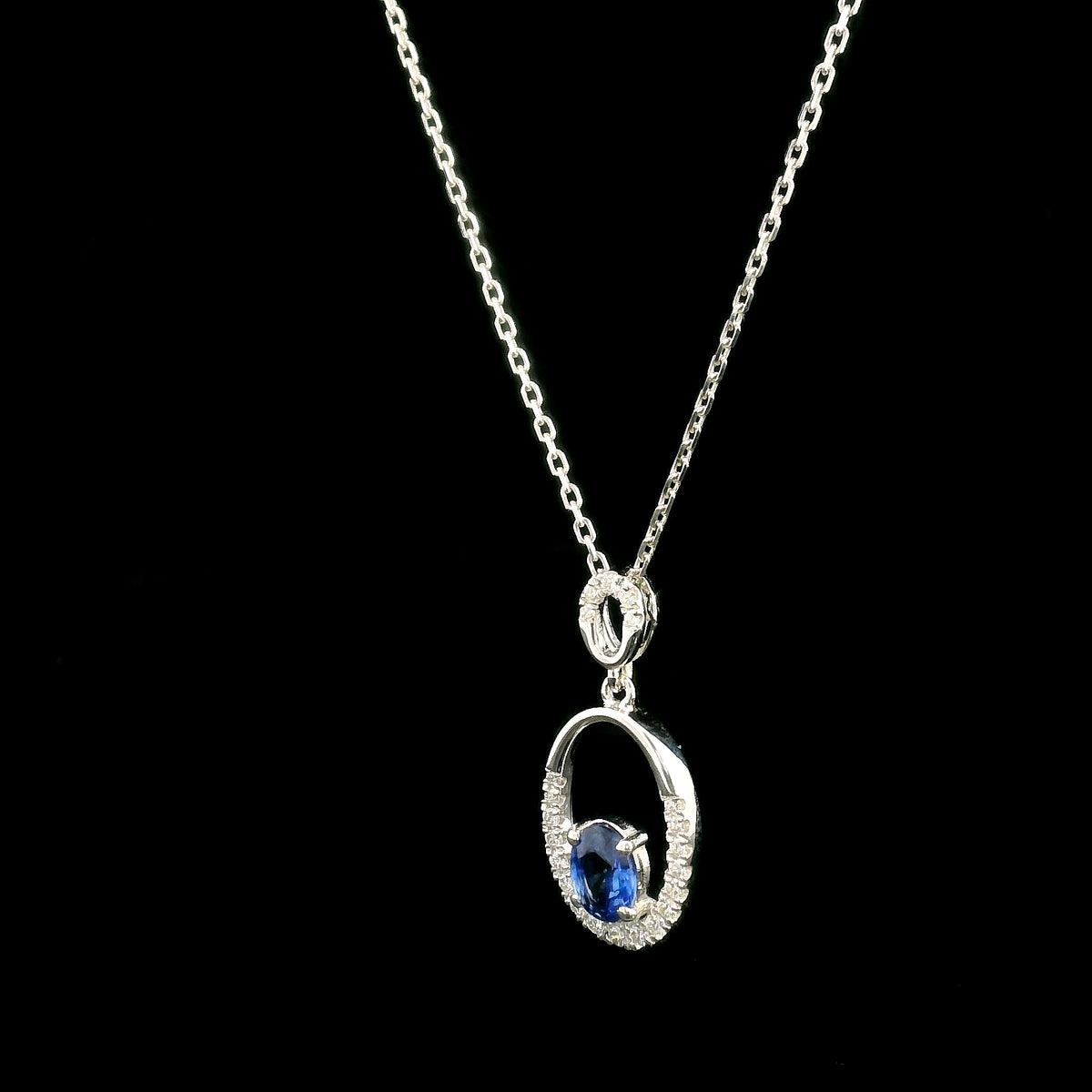 Oval blue sapphire and diamond pendant in 18K white gold with open oval design