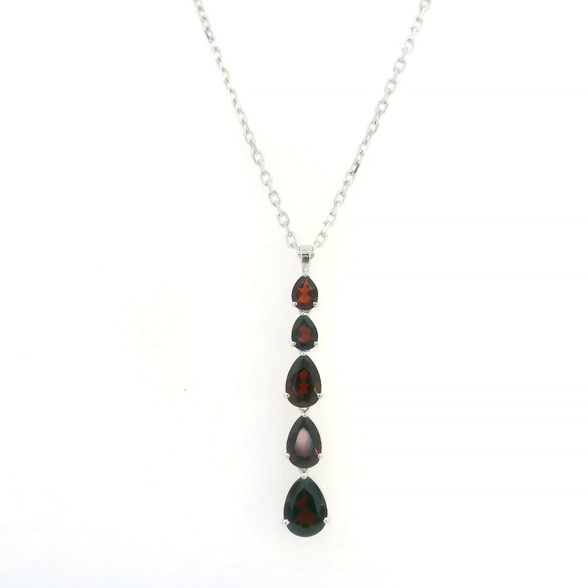 Pear shaped garnet drop pendant in 18K white gold featuring five graduated deep red garnets totalling 2.26 carat, arranged vertically in delicate prong settings. Chain  sold separately 