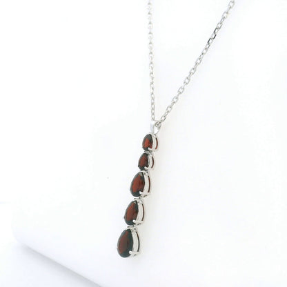 Pear shaped garnet drop pendant in 18K white gold featuring five graduated deep red garnets totalling 2.26 carat, arranged vertically in delicate prong settings. Chain  sold separately 