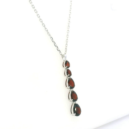 Pear shaped garnet drop pendant in 18K white gold featuring five graduated deep red garnets totalling 2.26 carat, arranged vertically in delicate prong settings. Chain  sold separately 