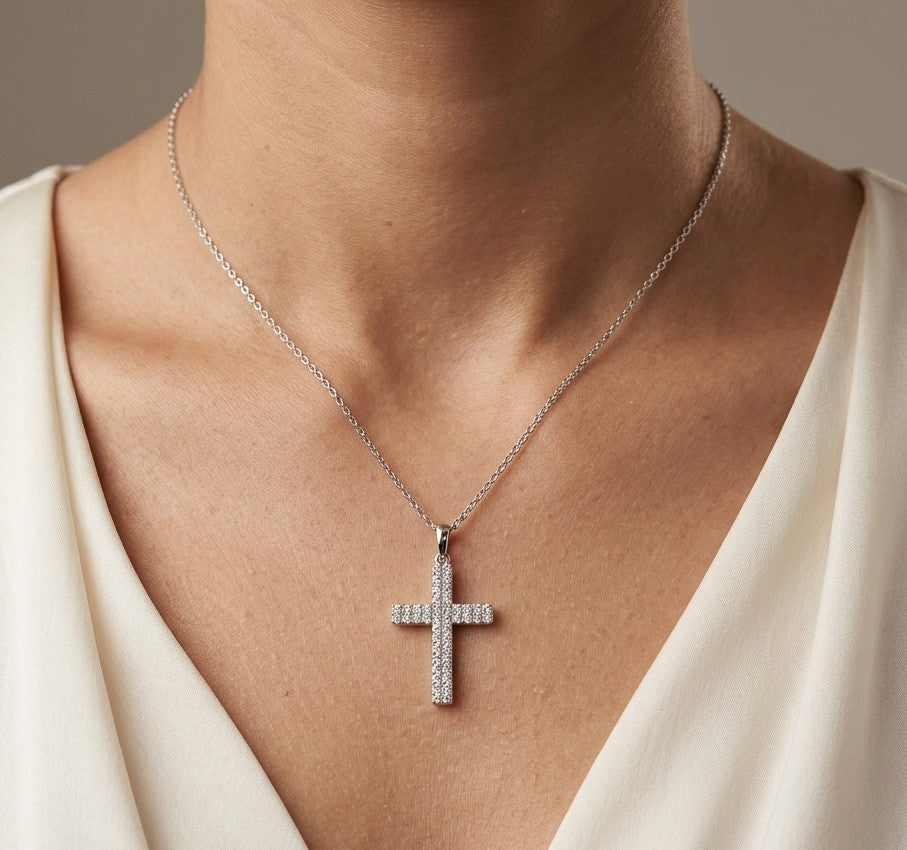 Diamond cross pendant in 18K white gold featuring a traditional cross design covered with multiple rows of round diamonds totalling 0.62 carat, shown on a chain for display.
