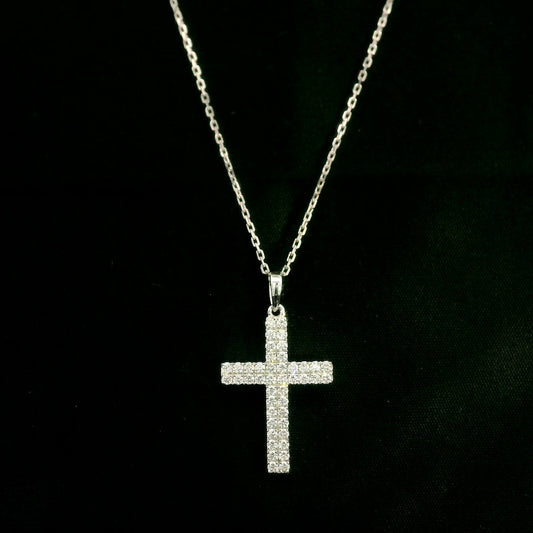 Diamond cross pendant in 18K white gold featuring a traditional cross design covered with multiple rows of round diamonds totalling 0.62 carat, shown on a chain for display.