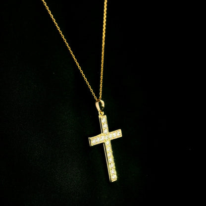18K yellow gold Christian cross pendant with round diamonds set along the vertical and horizontal arms, shown hanging from a fine gold chain.