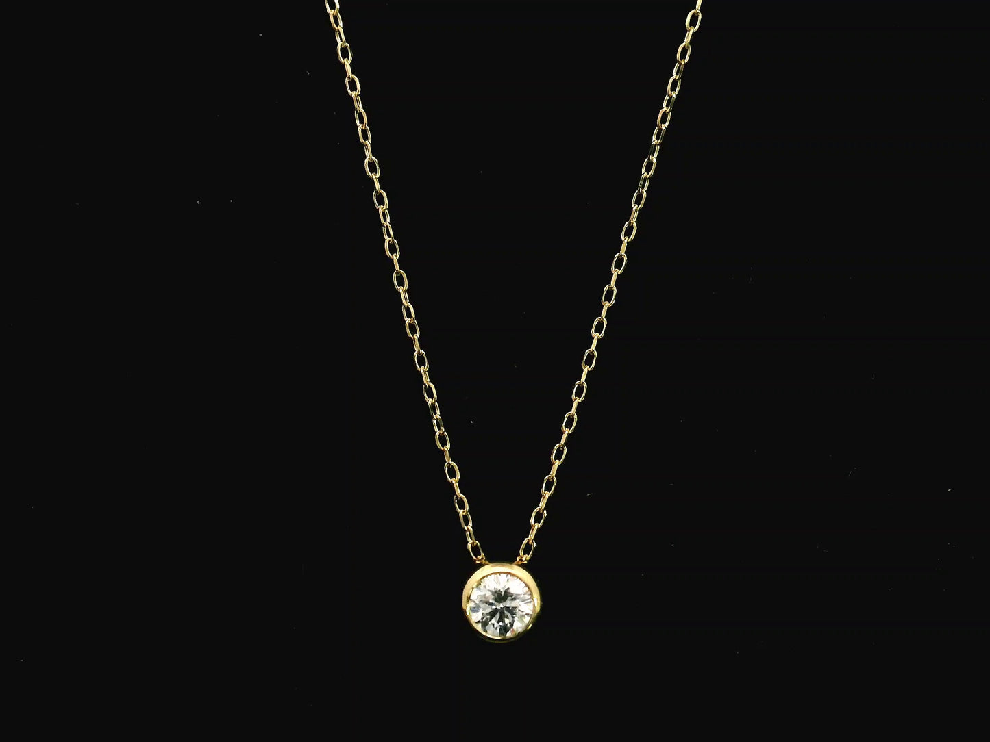 18K yellow gold diamond solitaire necklace featuring a 0.43 carat natural diamond in a modern bezel setting.