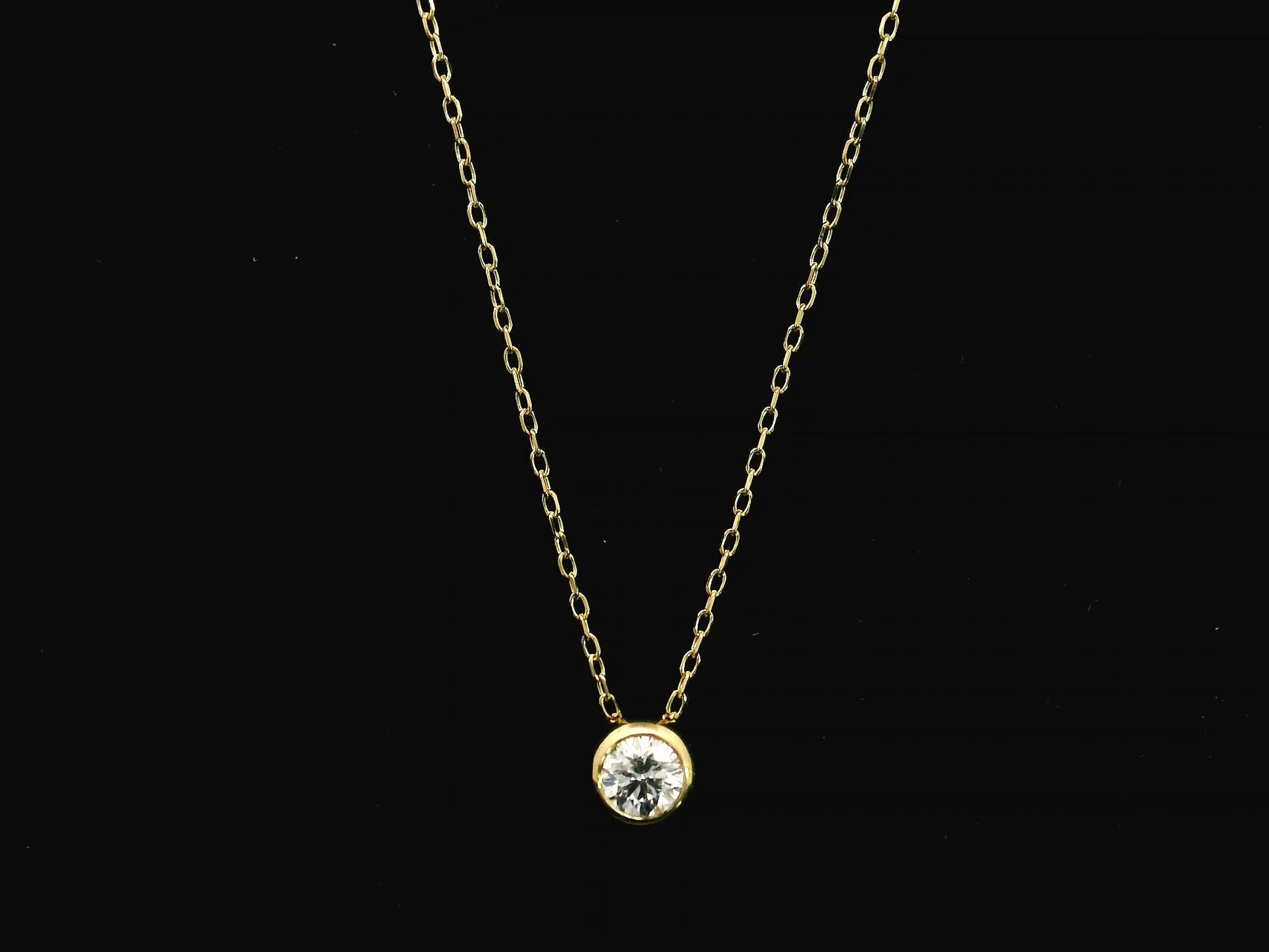 18K yellow gold diamond solitaire necklace featuring a 0.43 carat natural diamond in a modern bezel setting.