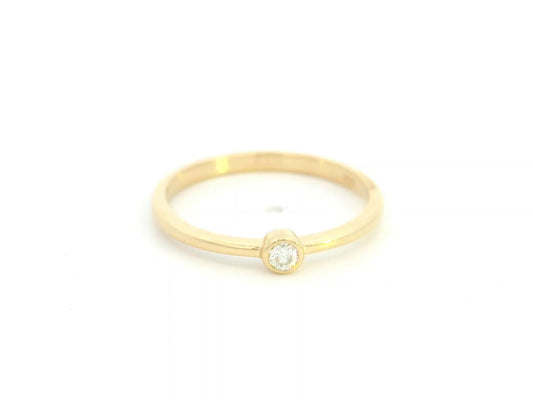 18K yellow gold bezel set diamond ring featuring a 0.07 carat natural round brilliant diamond in a minimalist solitaire design.