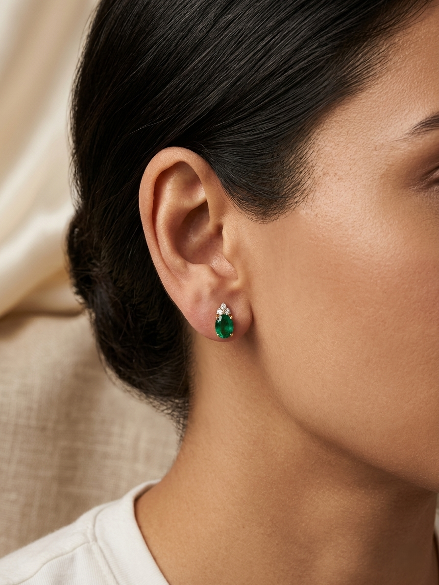 Emerald and diamond drop earrings in 18K yellow gold featuring 0.78 carat emeralds and 0.07 carat diamonds by Emirates Diamonds.
