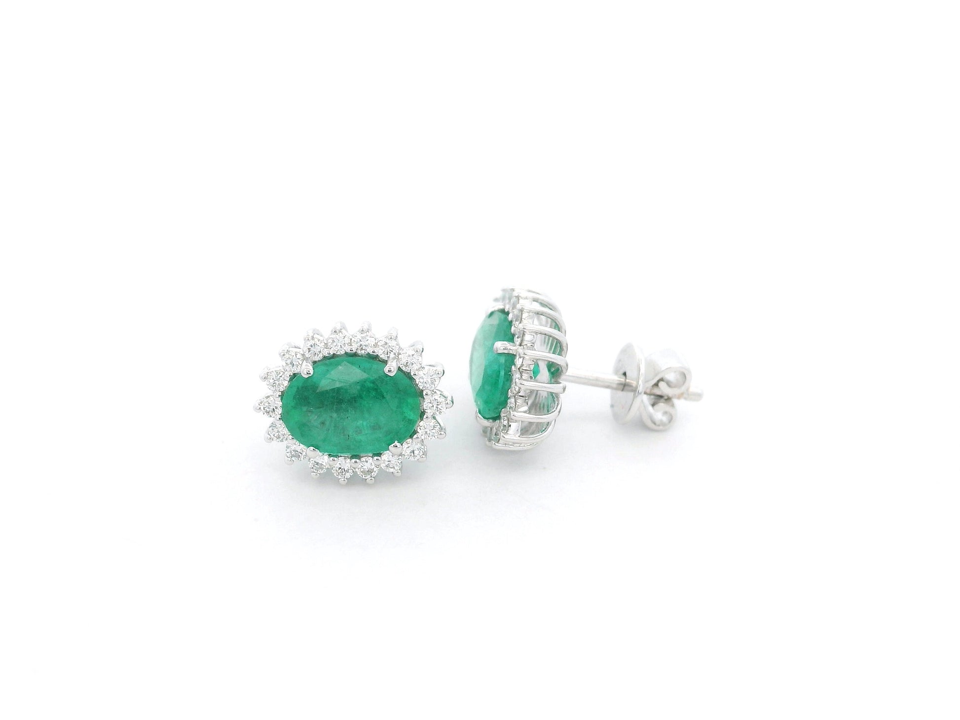 Emerald and diamond halo stud earrings in 18K white gold featuring 2.31 carat emeralds and 0.36 carat diamonds by Emirates Diamonds.
