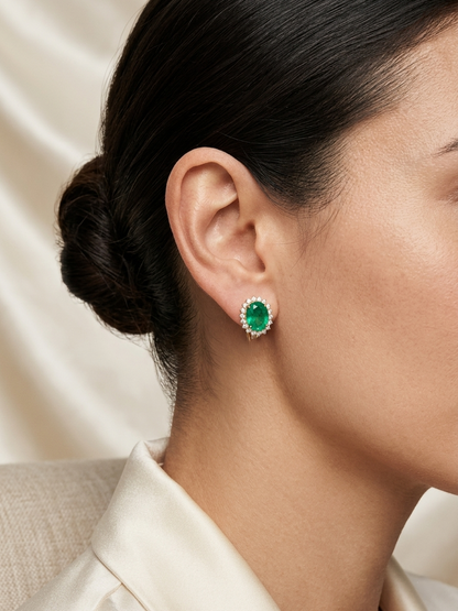 Emerald and diamond halo stud earrings in 18K white gold featuring 2.31 carat emeralds and 0.36 carat diamonds by Emirates Diamonds.