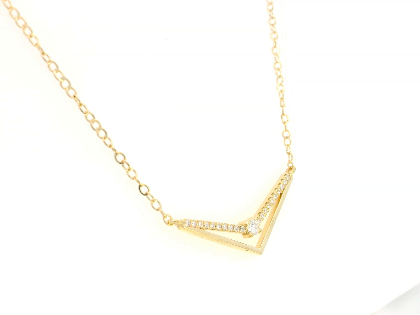 18K gold chevron diamond necklace with 0.16 carats of pavé diamonds on a V-shaped pendant, set on a delicate gold chain.