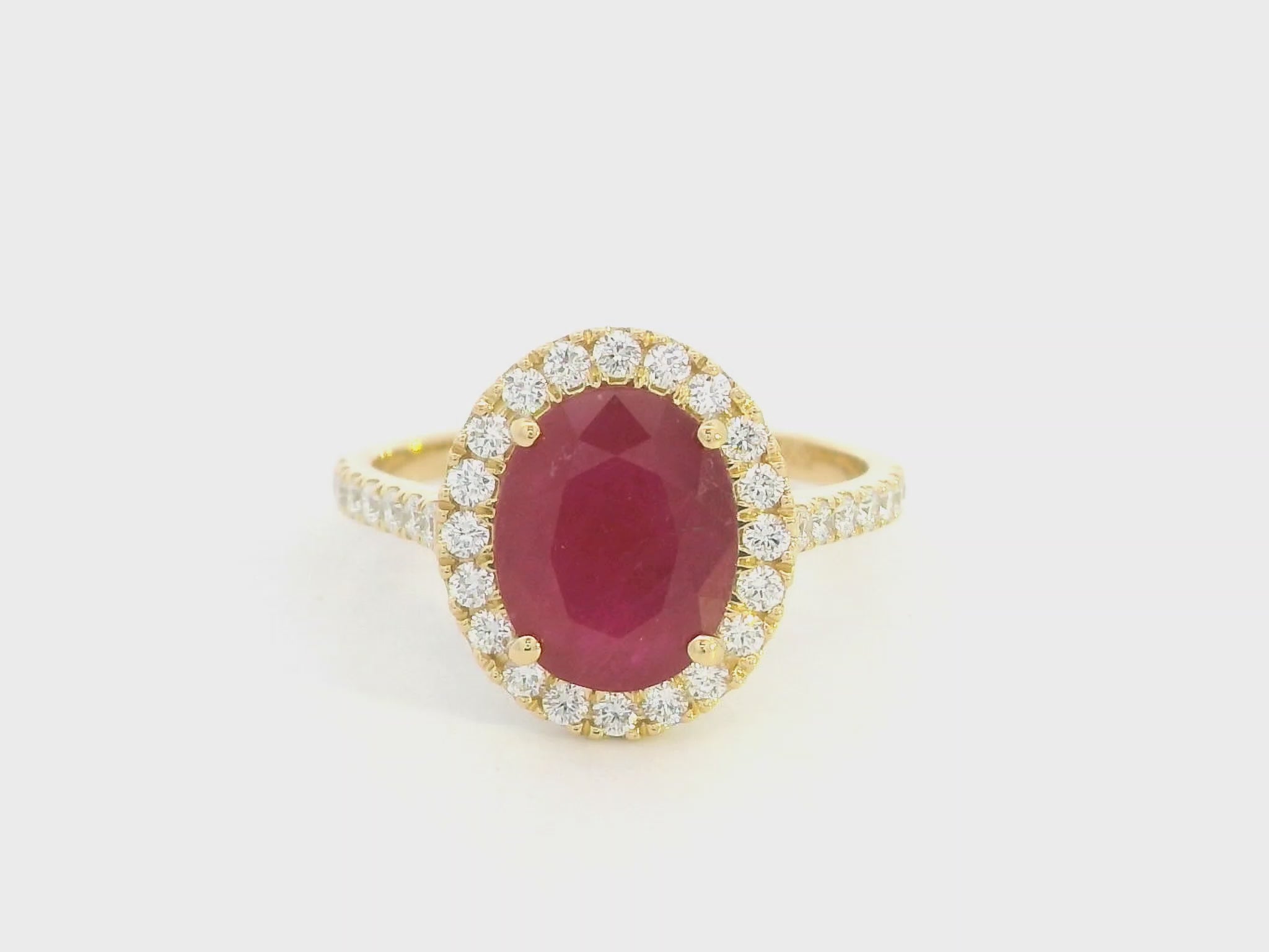 Oval ruby halo ring with diamonds in 18K yellow gold by Emirates Diamonds