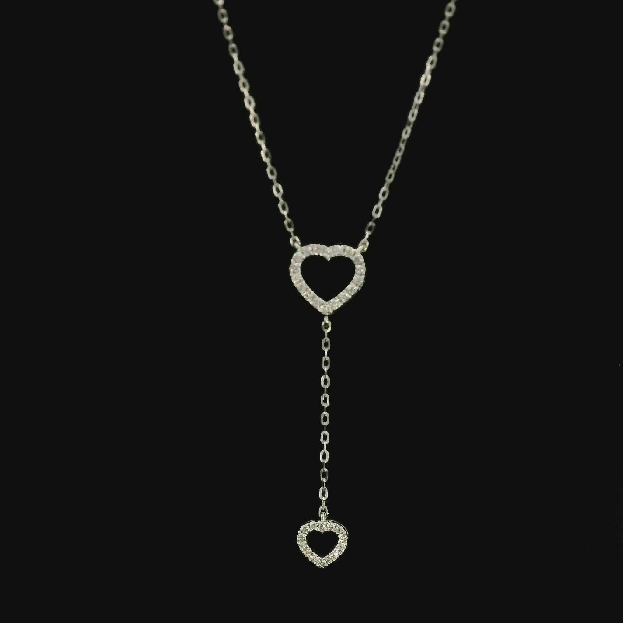 Diamond double heart Y necklace in 18K white gold featuring a larger open diamond heart at the neckline and a smaller diamond heart suspended from a delicate vertical drop chain, with 0.23 carat total diamond weight.