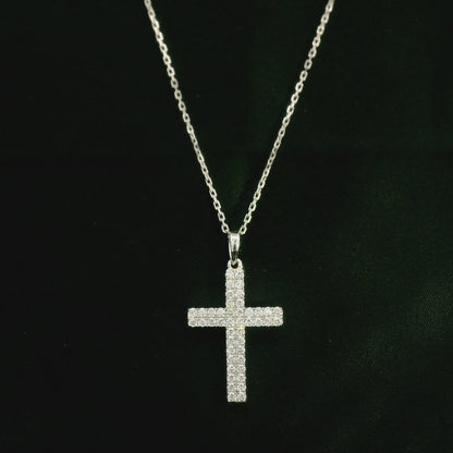 Diamond cross pendant in 18K white gold featuring a traditional cross design covered with multiple rows of round diamonds totalling 0.62 carat, shown on a chain for display.