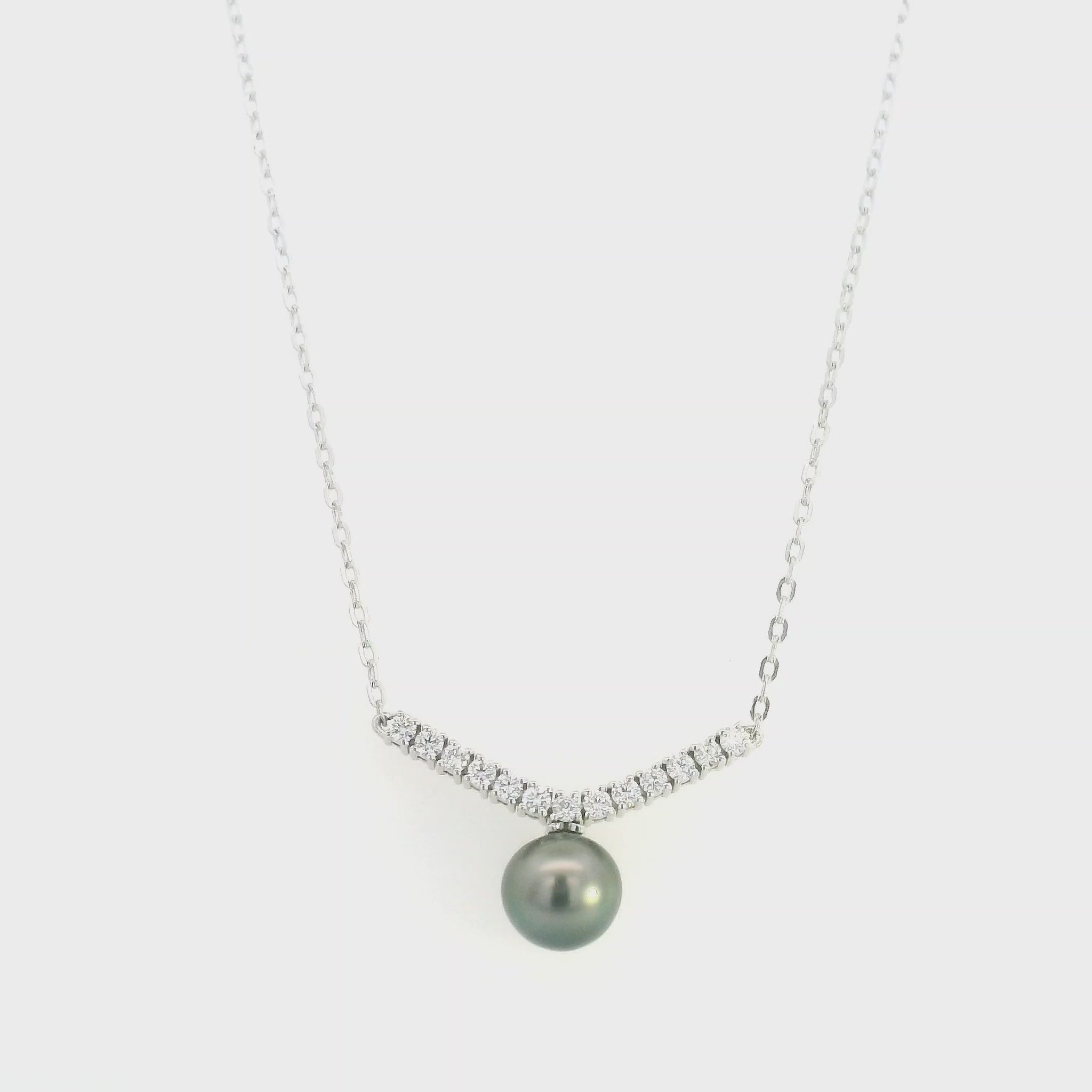 Tahitian black pearl and diamond necklace in 18K white gold featuring a dark grey pearl suspended beneath a gently curved row of round diamonds on a delicate white gold chain.