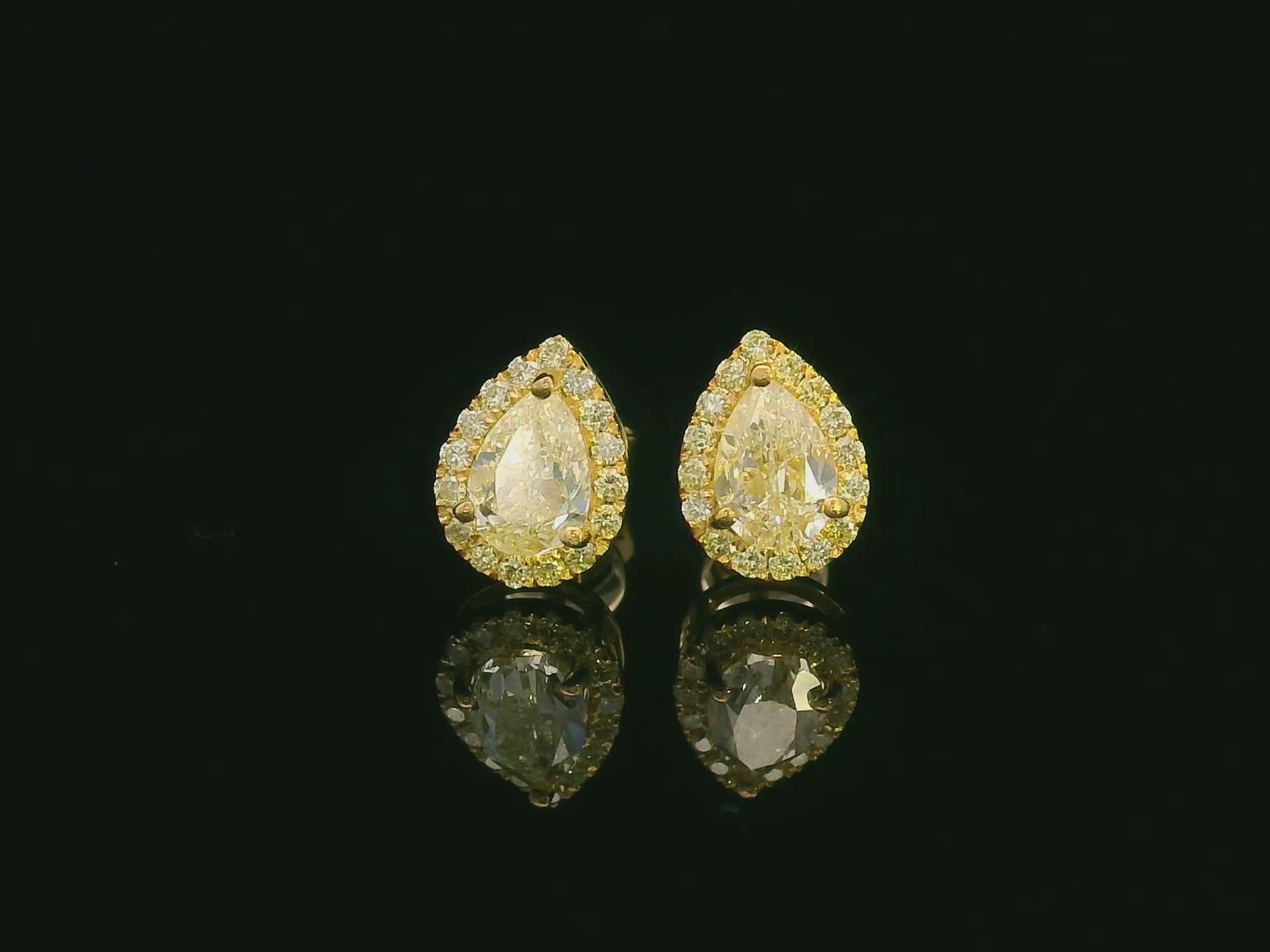 Pear-shaped fancy yellow diamond halo earrings in yellow gold setting
