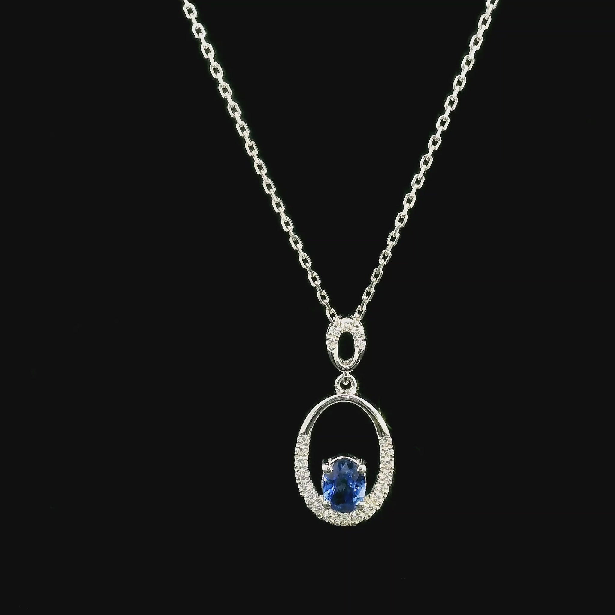 Oval blue sapphire and diamond pendant in 18K white gold with open oval design