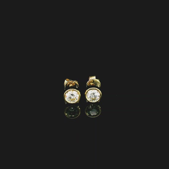 18K yellow gold bezel-set diamond stud earrings with round brilliant diamonds.